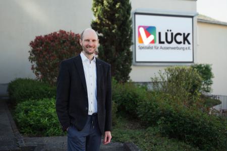 Sebastian Lück, Inhaber von Lück Spezialist für Außenwerbung e. K, bei der Begutachtung einer vermittelten Werbeanlage