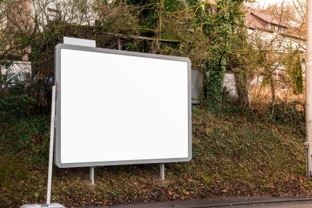 Ein Bild von einem großen Werbeschild auf einem Erdwall als Beispiel. Das Schild ist fest betoniert in der Erde.